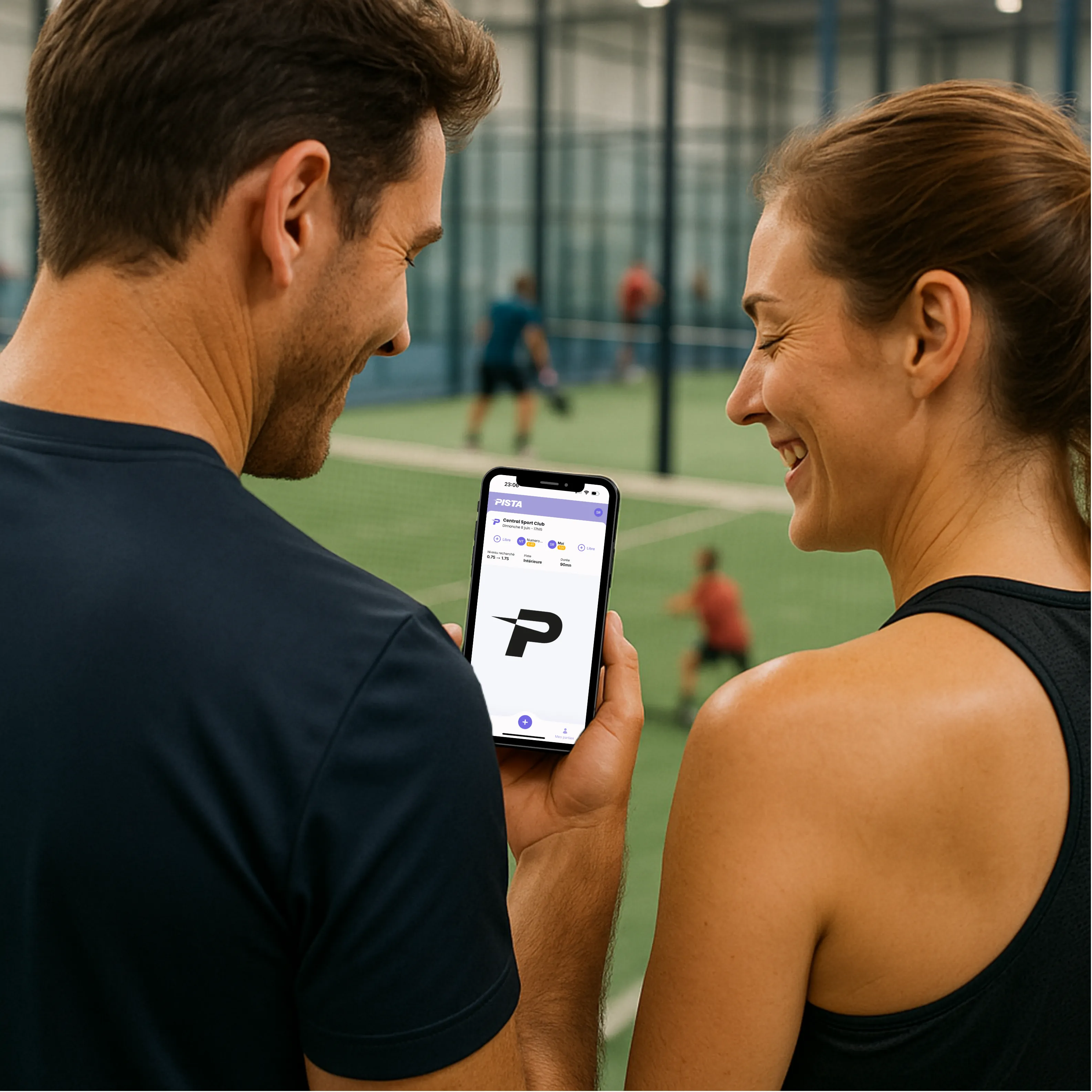 Joueur de padel tenant son téléphone avec l'app PISTA